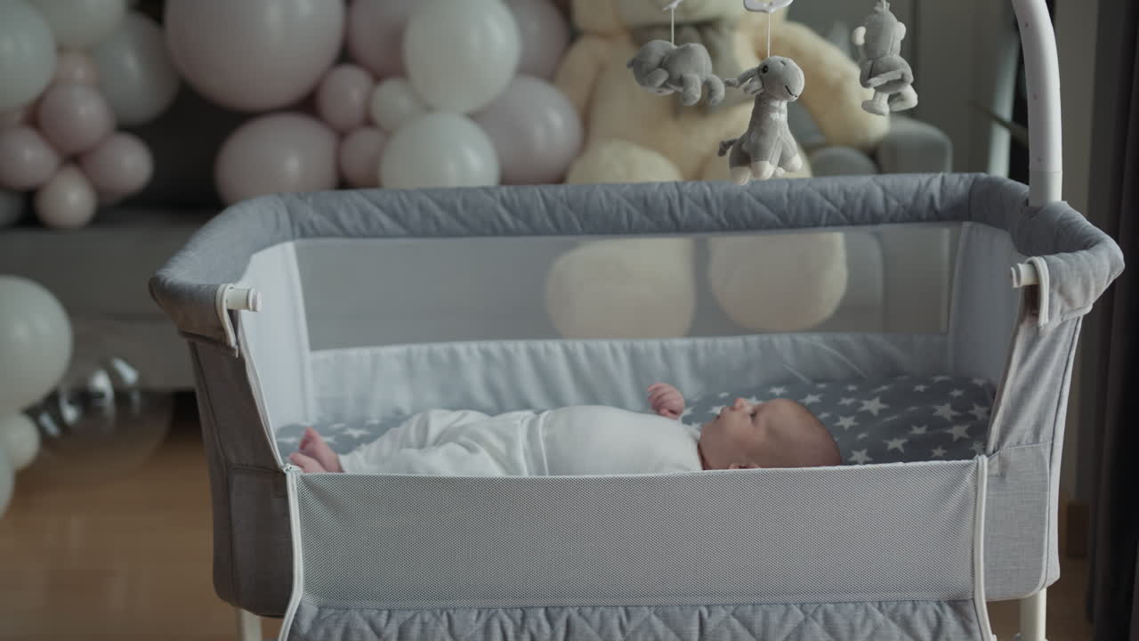Neonato riposa serenamente nella culla con palloncini e orsetto di peluche, arredamento accogliente per la cameretta, baby shower.