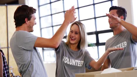 Voluntarios-Sonrientes-Chocando-Los-Cinco-Entre-Sí.