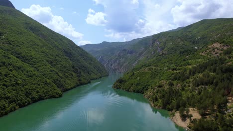 a boat sails across the komani lake in noth albania