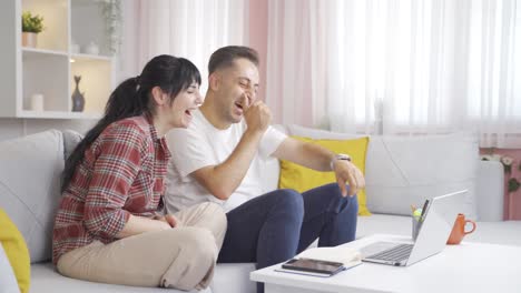 Couple-watching-comedy-movie-on-laptop.-They-are-having-fun.