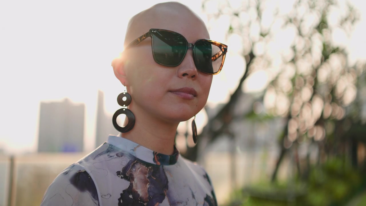 Portrait of a Stylish Bald Woman Wearing Sunglasses Outdoors