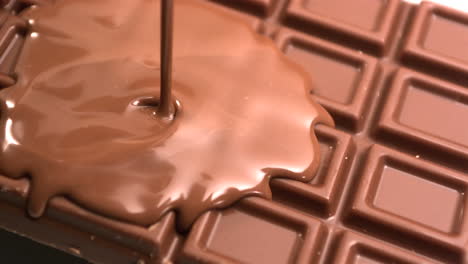 melted chocolate being poured over a bar of chocolate