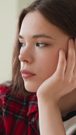 sad woman leans on hand at table closeup. worried lady student hides truth about expelling from collage from parents at home. depressive mood