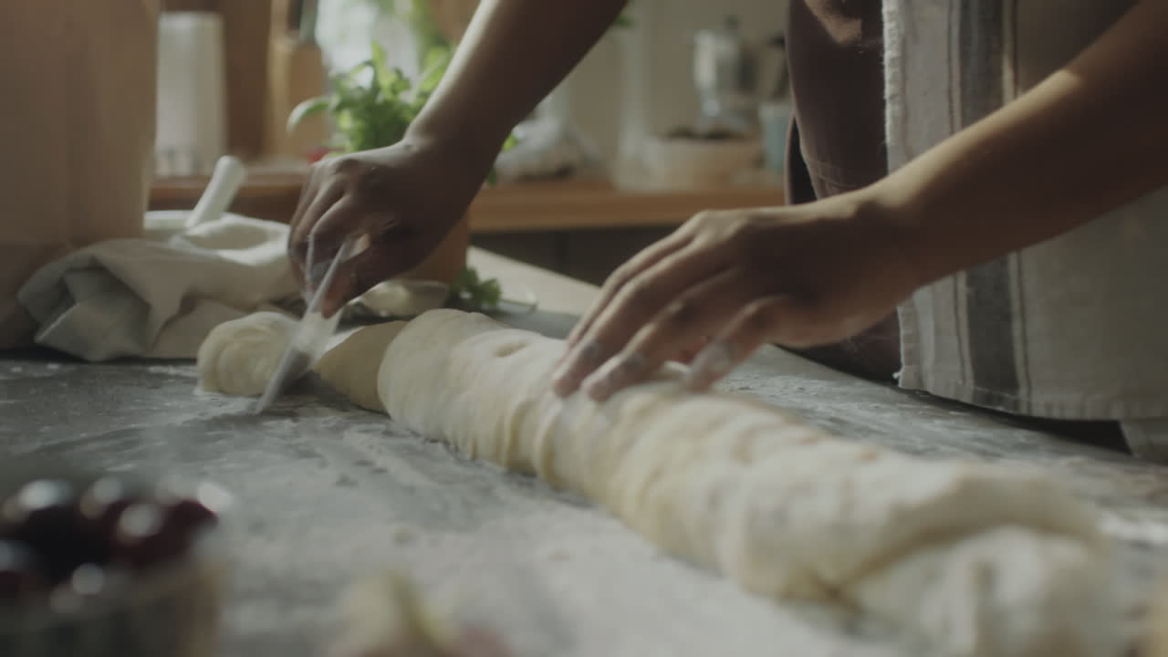 Hands preparing dough for baking in a kitchen