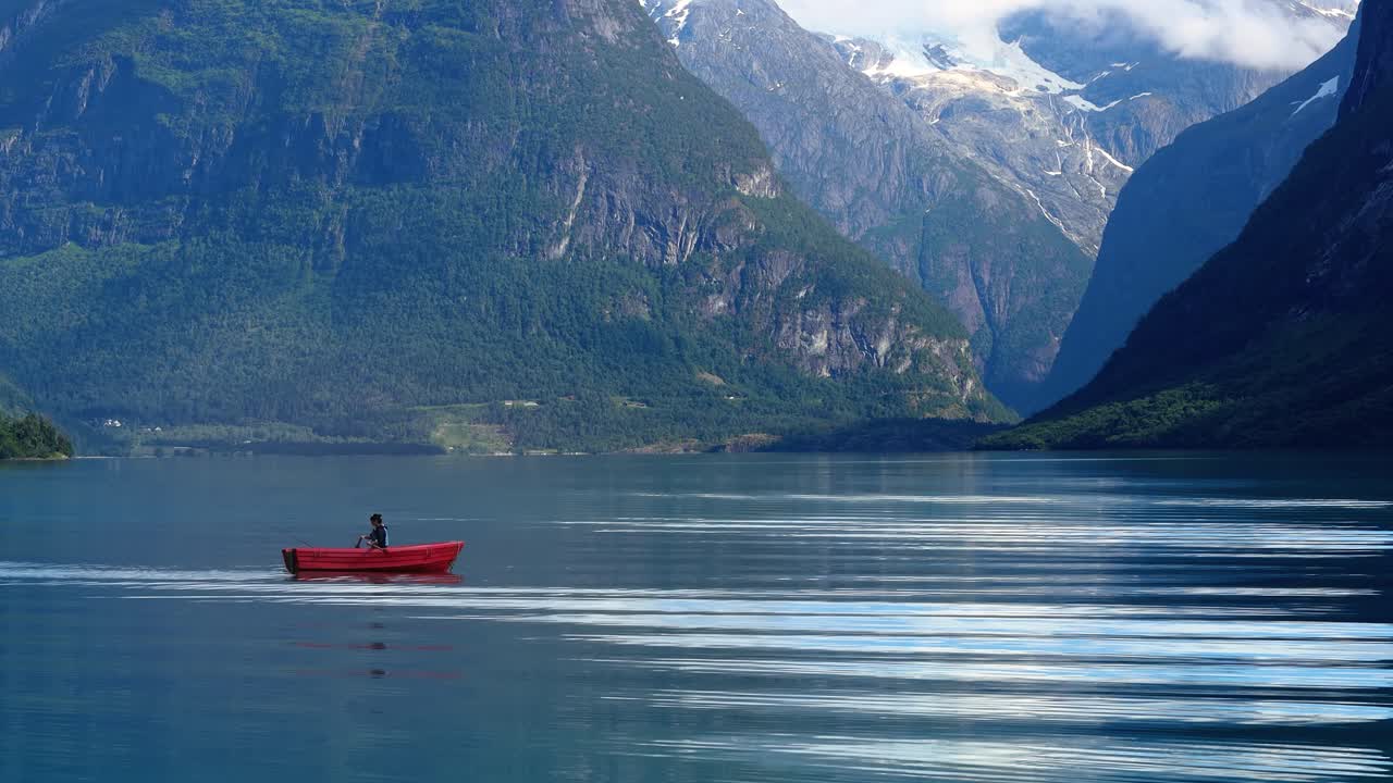 보트에 있는 여자가 노르웨이에서 물고기를 잡습니다.