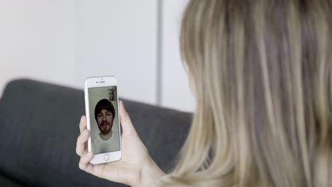 vista trasera de una mujer joven haciendo una llamada de video con su marido.