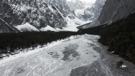 Aerial:-Yulong-glacier-in-Yunnan-China,-view-over-hiker-in-icy-glacial-valley