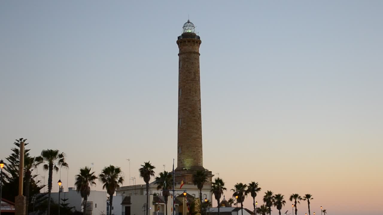 Faro bellissimo. Luce dorata sul faro di Chipiona e sulla spiaggia a Cadice, Spagna, al tramonto.