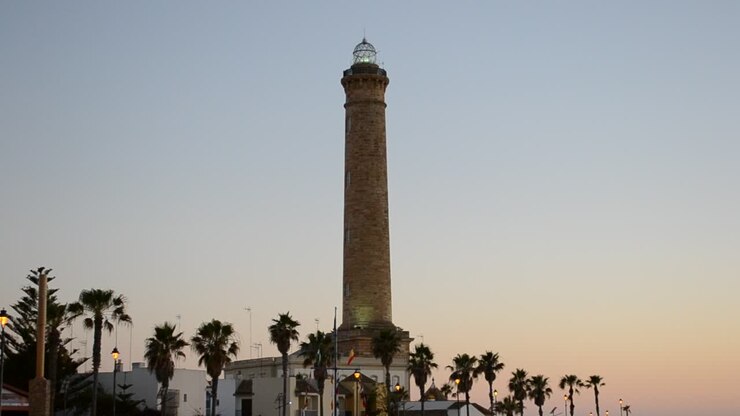 Faro bellissimo. Luce dorata sul faro di Chipiona e sulla spiaggia a Cadice, Spagna, al tramonto.