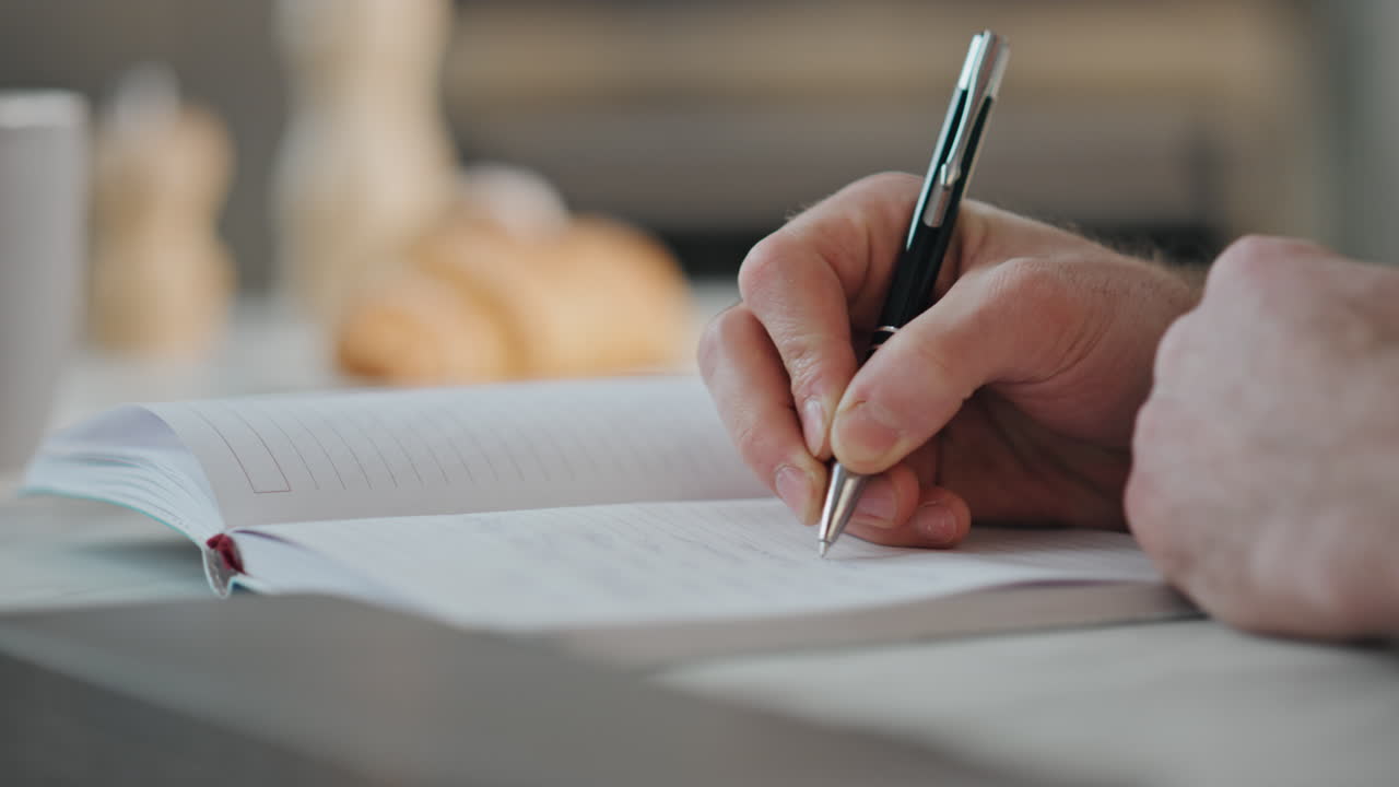Man hands writing notepad at home close up. Student studying noting information