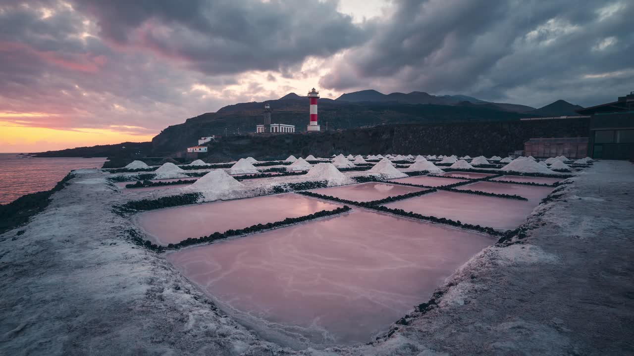 lapso de tiempo de salinas de fuencaliente salinas líneas principales y faro durante la colorida puesta de sol con nubes naranjas y rojas
