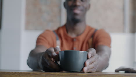 man holding a coffee cup in a cafe