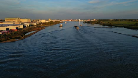 Cargo-ships-sailing-Schelda-river-near-Zwijndrecht,-Netherlands,-panoramic-view,-Flying-over-river-with-industrial-ship-sailing