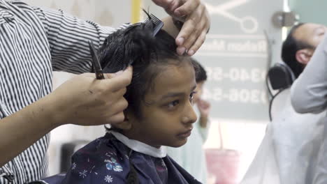 young boy getting a haircut at a barbershop