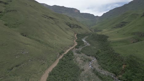 Bird's-eye-view-as-AWD-vehicle-drives-rough-dirt-road-to-Sani-Pass,-ZA