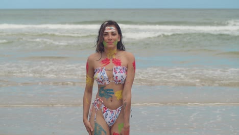 a sunny caribbean day sets the scene for a girl adorned in body paint and a bikini on a white sand beach