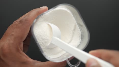 scooping protein powder into a container