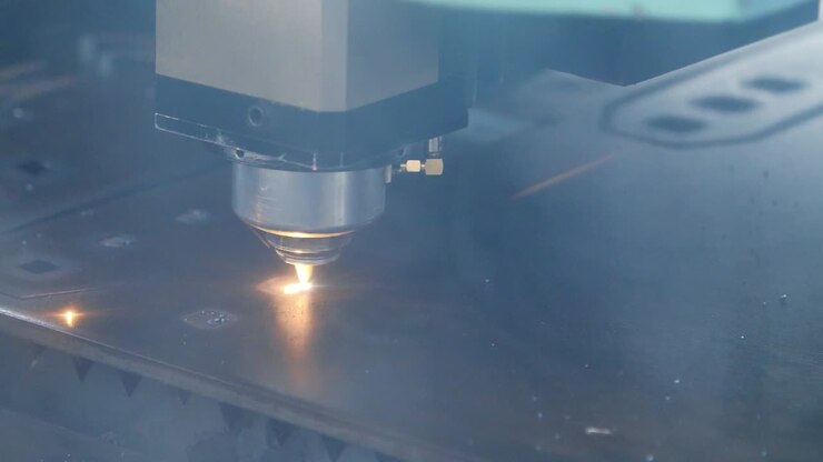 Taglio laser di lamiera con scintille. Attrezzatura industriale in stabilimento.