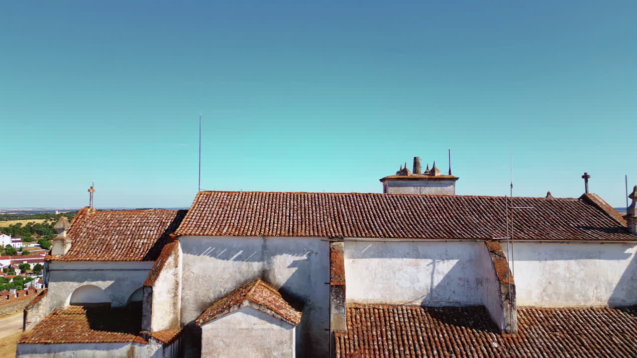Drone sopra un antico monastero portoghese che si erge su un insediamento illuminato dal sole. Mura fortificate