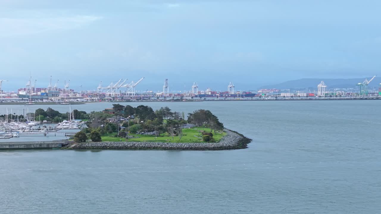 From a high vantage point, a drone view of the Emeryville Marina Park, revealing boats and cranes in the background.