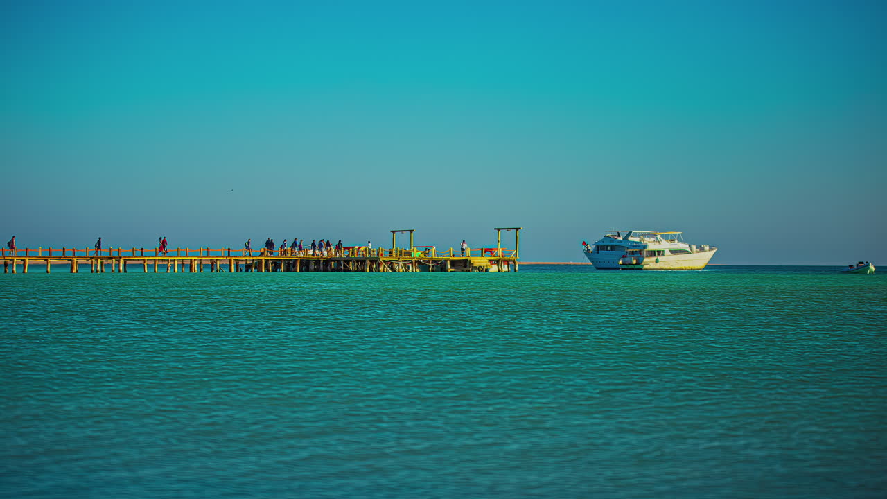 사람들은 이집트 후르가다의 오렌지 베이에 있는 부두에 모여듭니다 - 홍해에서 요트로 저속 촬영