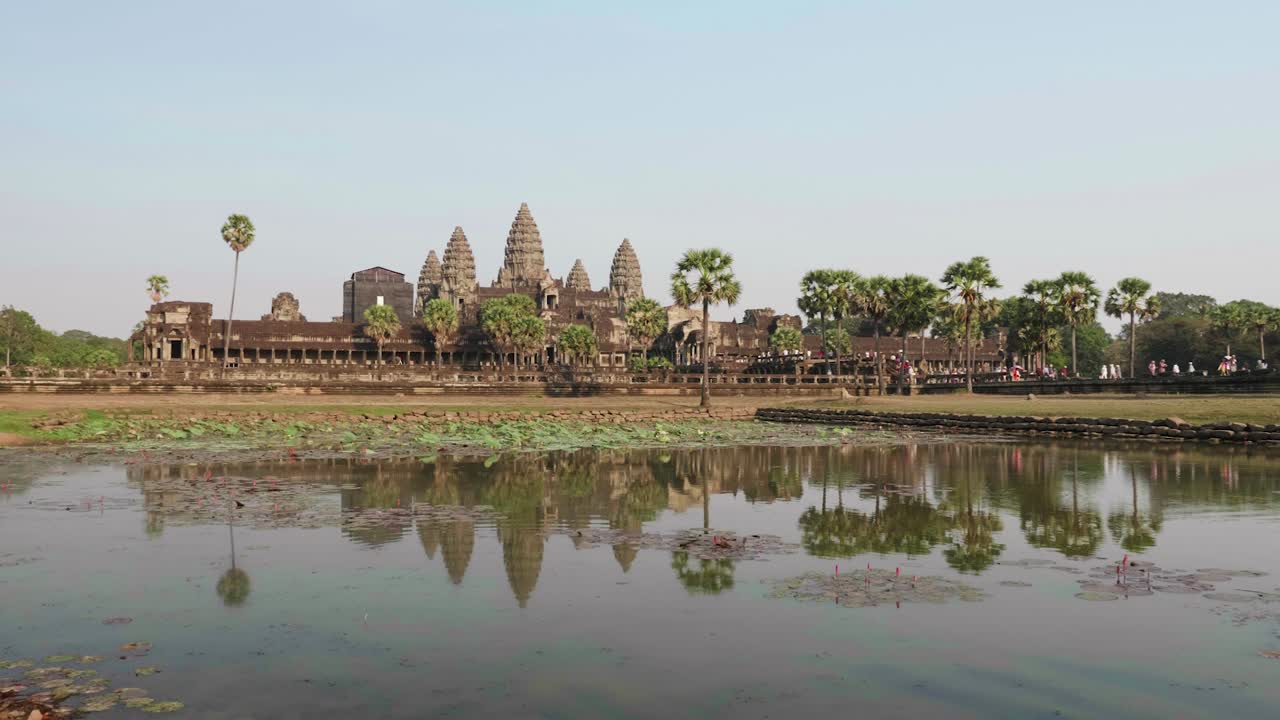 Forward Dolly Towards The Main Temple Of Angkor Wat. Recorded From The Left Pond With Reflection In The Water