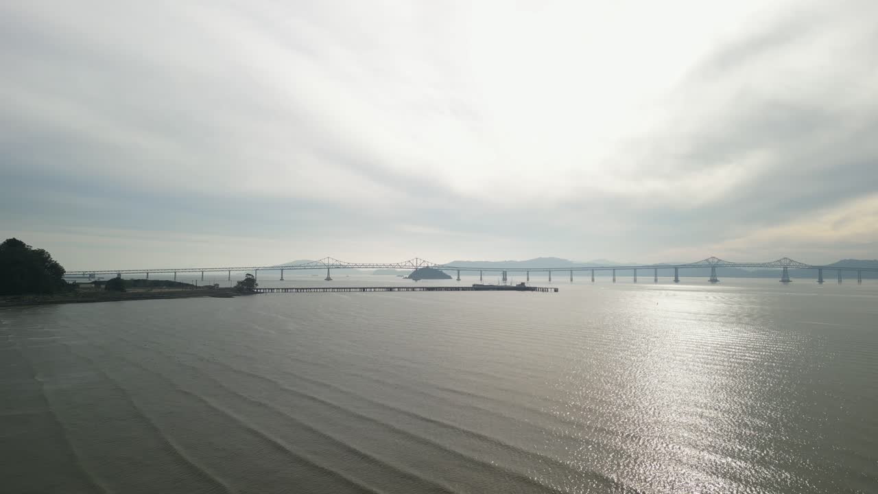 Aerial view displays the Richmond–San Rafael Bridge with Point Molate Beach’s rugged shoreline.