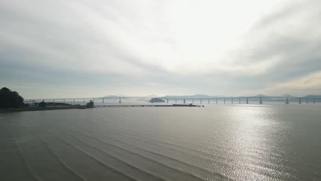 aerial view displays the richmond–san rafael bridge with point molate beach’s rugged shoreline.