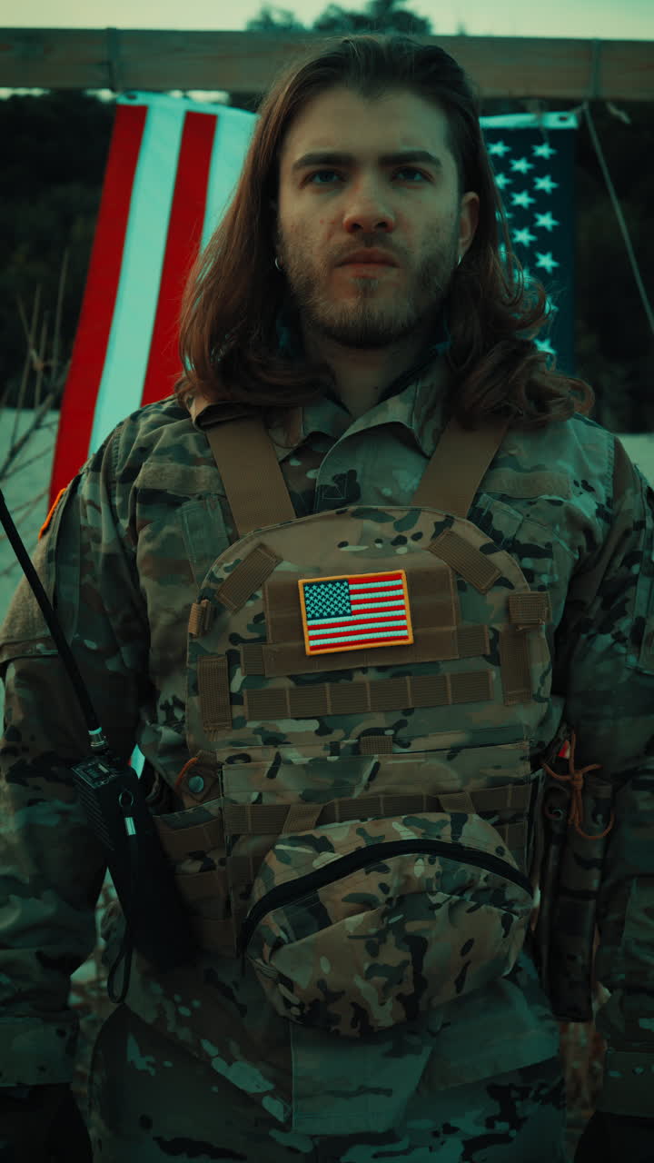 Un soldato americano saluta di fronte a una bandiera che sventola di notte in un memoriale militare