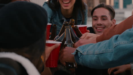 grupo de amigos bebiendo alcohol haciendo tostadas divirtiéndose en la azotea reuniéndose disfrutando de pasar el rato juntos charlando compartiendo pizza al atardecer