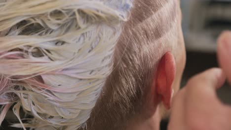 rear view woman having her hair cut by a hairdresser