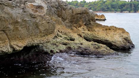 calm waves hiting rocks on a gloomy day