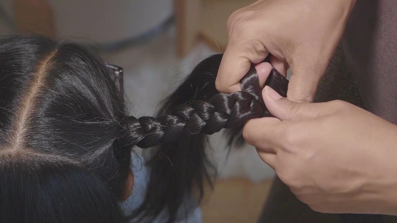 Close-up of Hands Braiding Long Dark Hair