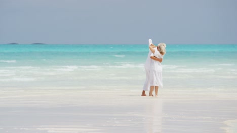 mature caucasian couple walking together on tropical beach