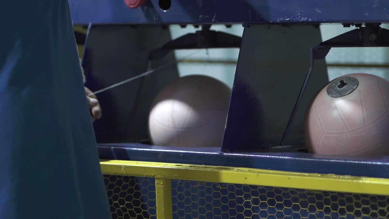 공장 노동자는 그녀의 작업 스테이션에서 다음 공을 가지고 일합니다.