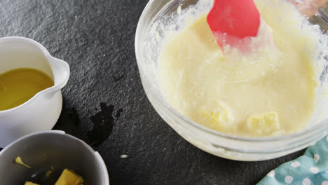 Woman-adding-butter-cubes-to-batter-in-bowl-4k