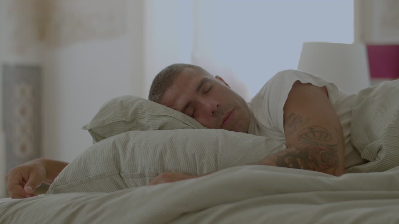 hombre caucásico durmiendo en la cama en un apartamento