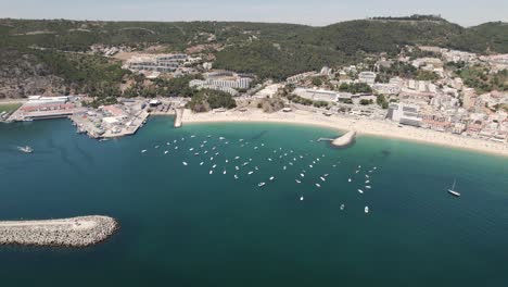 boats moored in blue sea of sesimbra in portugal. aerial drone view