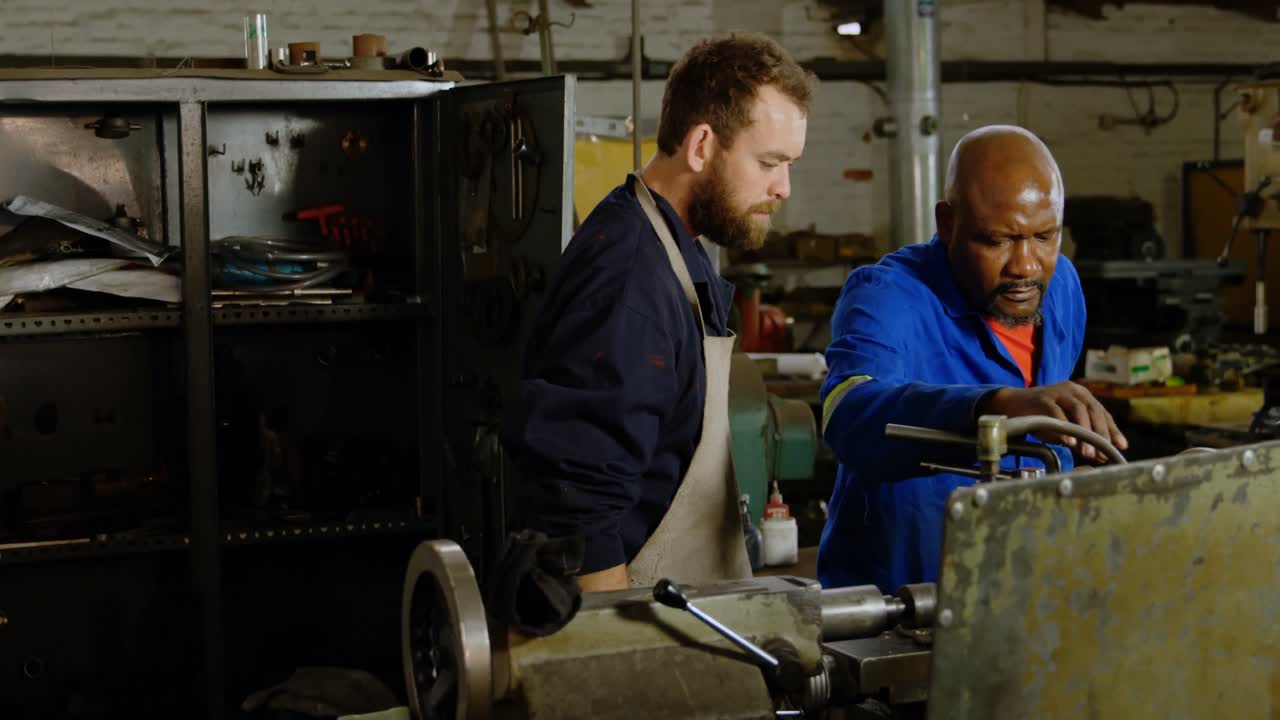 Two metalsmiths working on machine 4k