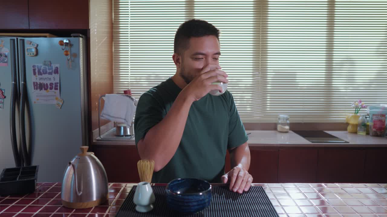 Man enjoying matcha tea ceremony in kitchen