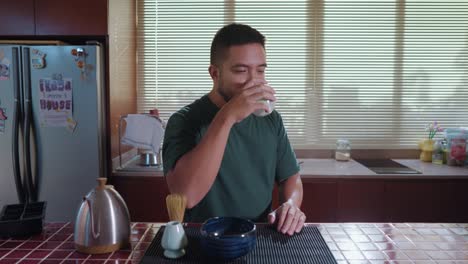 man enjoying matcha tea ceremony in kitchen