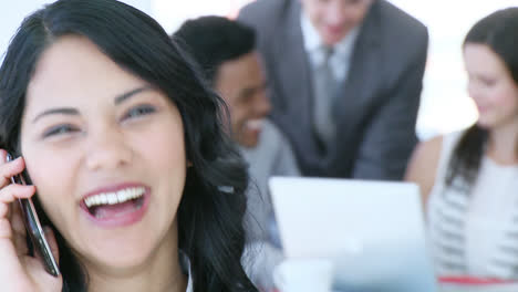 businesswoman on mobile with her team working in office