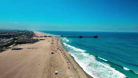 drone flying down and towards the pier in huntington beach california