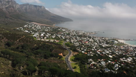 drone shot over camps bay along the coast of cape town, south africa