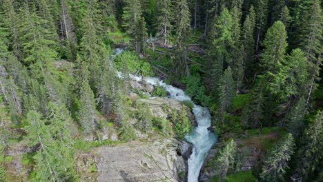 Cascate-del-rutor-waterfall-flowing-through-a-lush-green-forest,-aerial-view