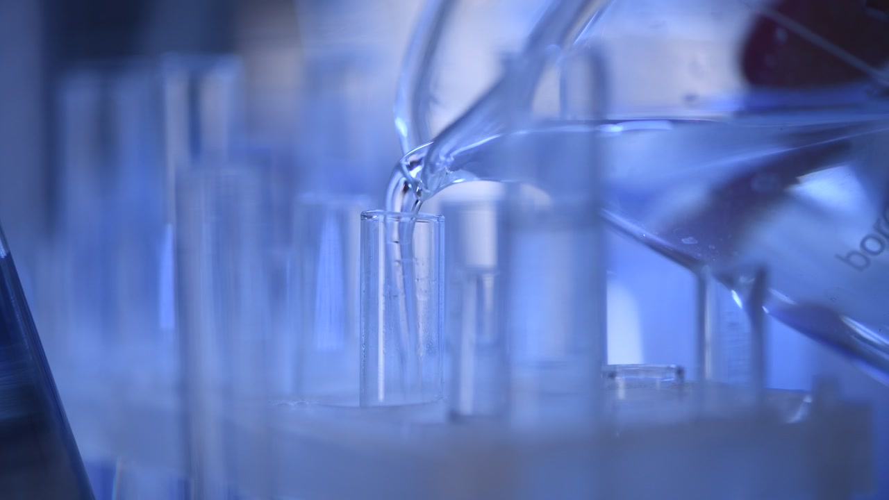 Pouring Clear Liquid into a Test Tube in a Laboratory