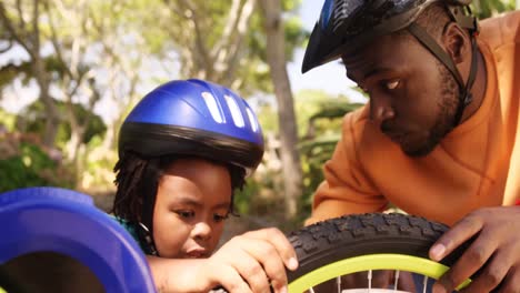 Close-up-of-father-is-helping-his-son-to-repair-the-bike-