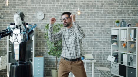 trabajador de oficina alegre bailando con un robot en el trabajo divirtiéndose disfrutando del descanso