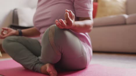 mid section of asian senior woman practicing yoga and meditating at home