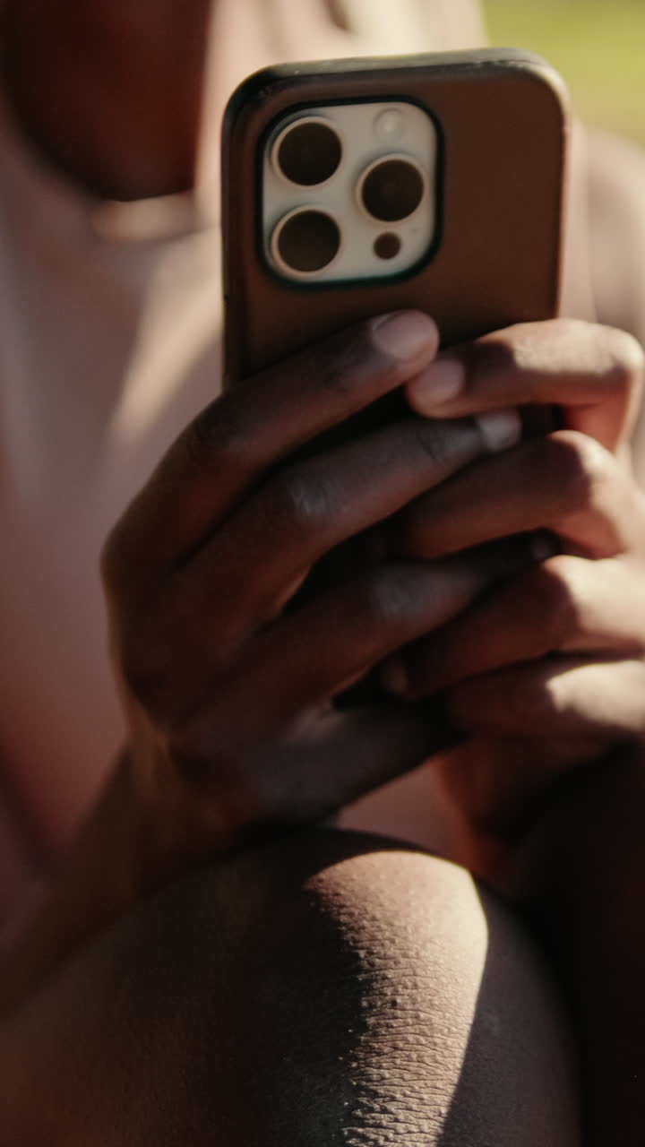 Close-up of Person's Hands Holding and Using a Smartphone Outdoors